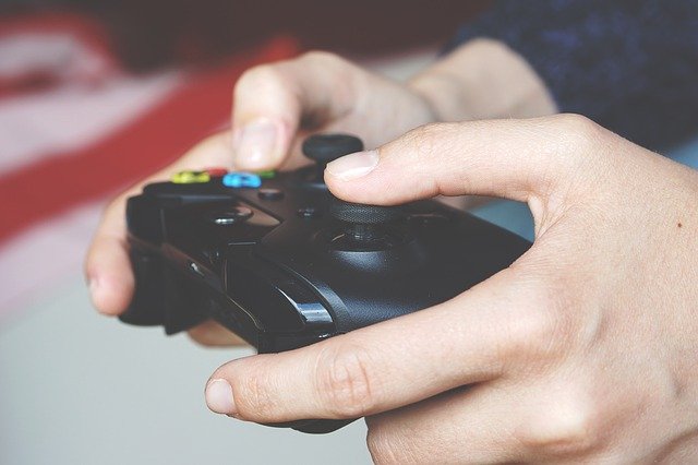 A boy plays a video game.  He is holding a video game controller.  